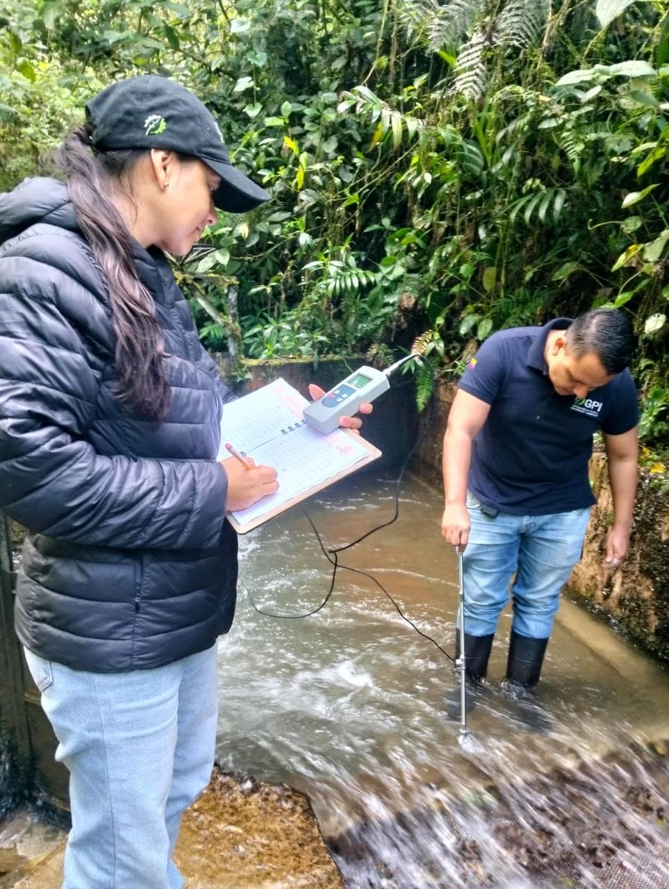 Dos profesionales de GPI registrando datos durante un monitoreo de calidad del agua en campo